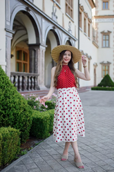 a lady wears a red polka dots halter top with a matching white midi skirt